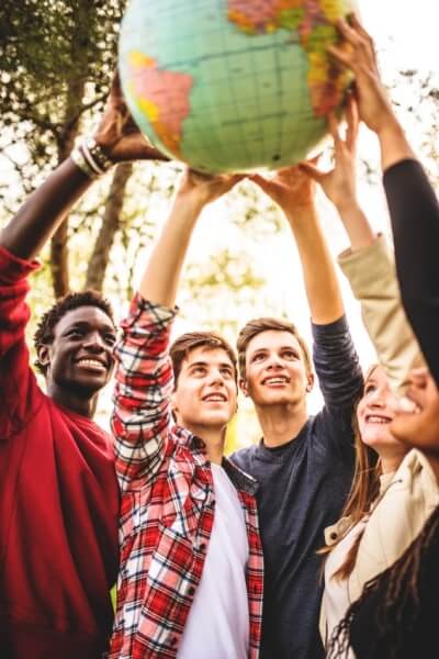 Five students holding a globe outside