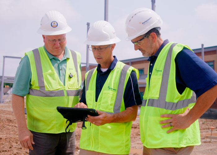 Performance Services design-build team on an active jobsite in hard hats and safety vests