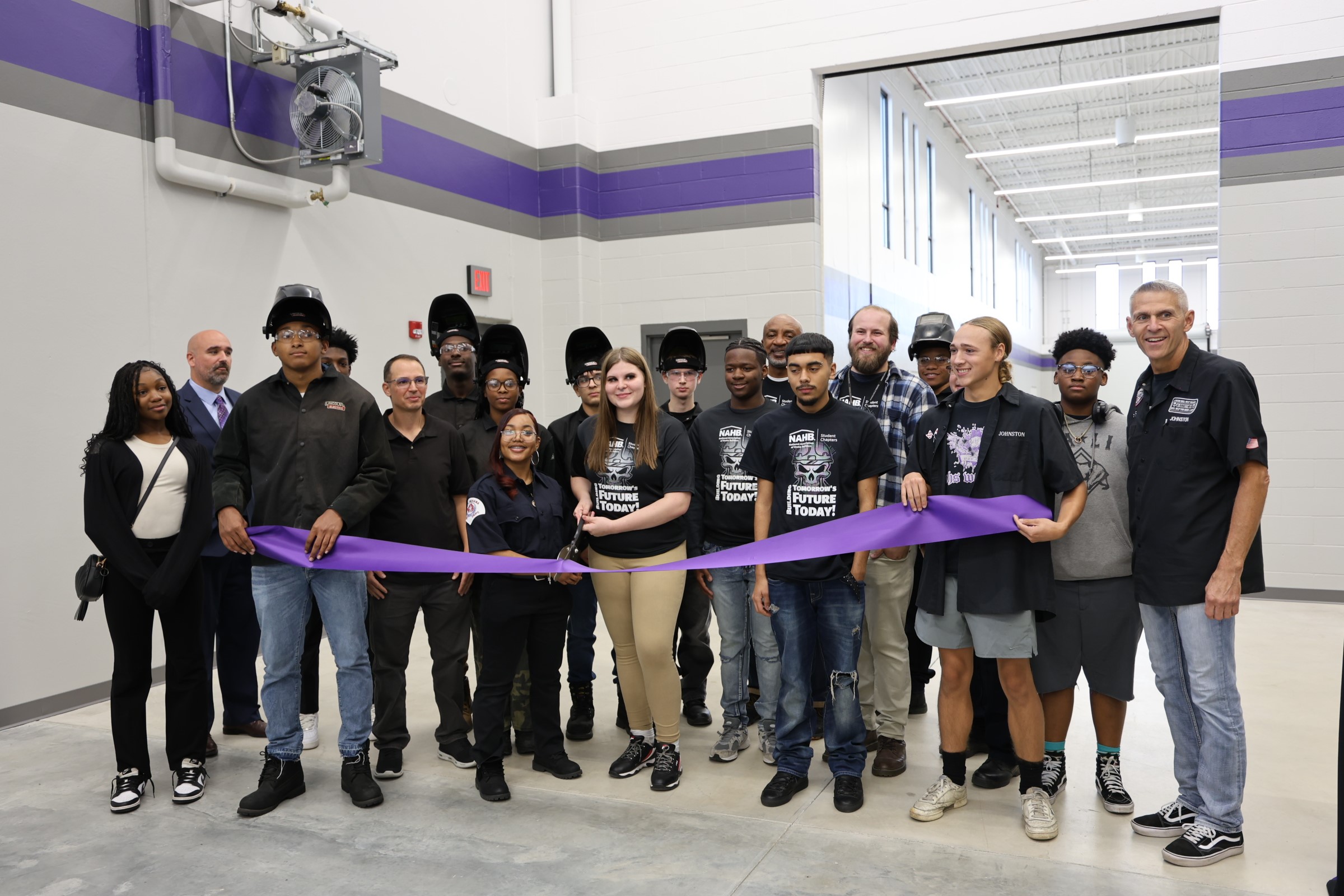 Students and staff from Merrillville Community Schools cutting a purple ribbon to celebrate the opening of the new career and technical education wing