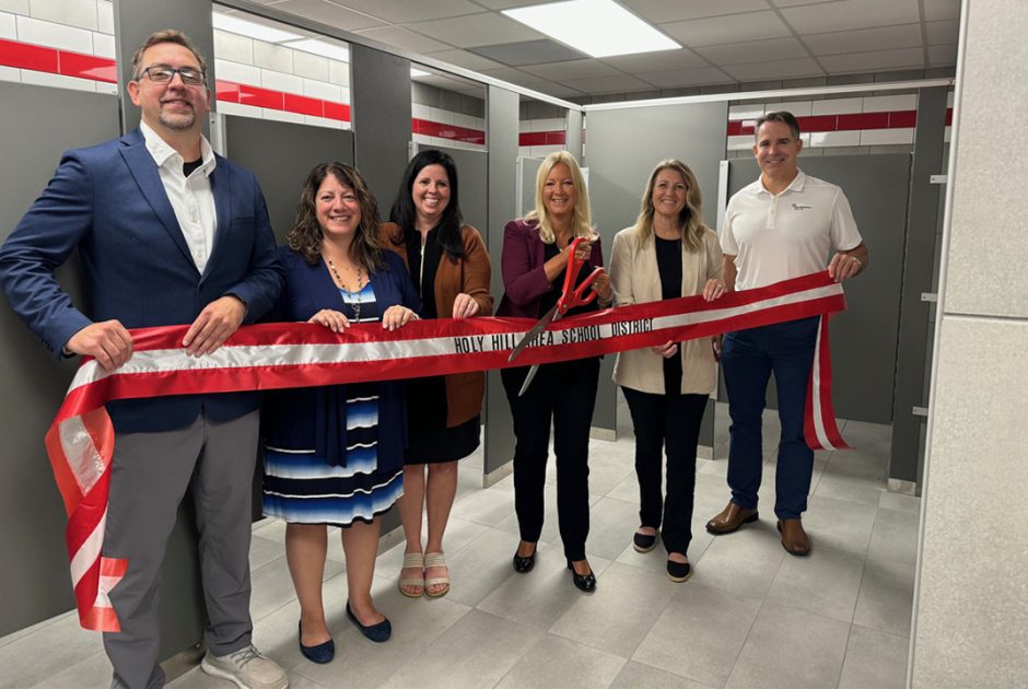 Holy Hill Schools admin team cutting ribbon in front of new renovated bathrooms